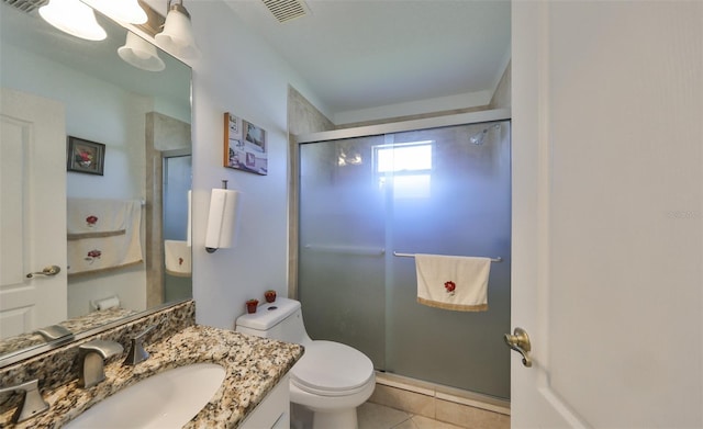 bathroom featuring vanity, toilet, a shower with shower door, and tile patterned flooring