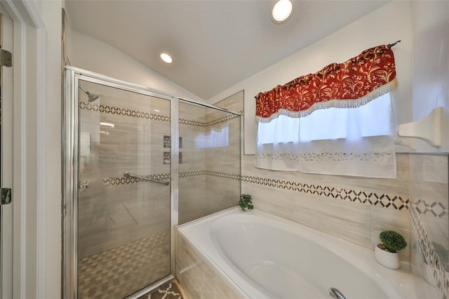 bathroom featuring vaulted ceiling and separate shower and tub