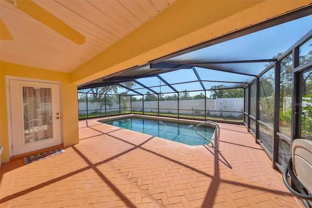 view of swimming pool with ceiling fan, a patio area, and a lanai