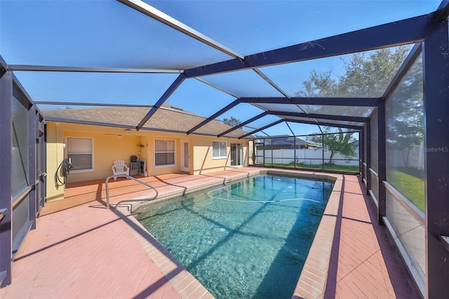 view of swimming pool featuring a patio area and a lanai