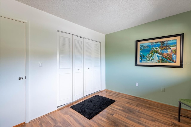 90 S Highland Ave Unit 1115, Tarpon Springs, FL 34689 - unfurnished bedroom with wood finished floors, a textured ceiling, and a closet