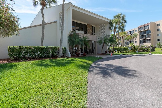 view of front of house with a balcony and a front lawn