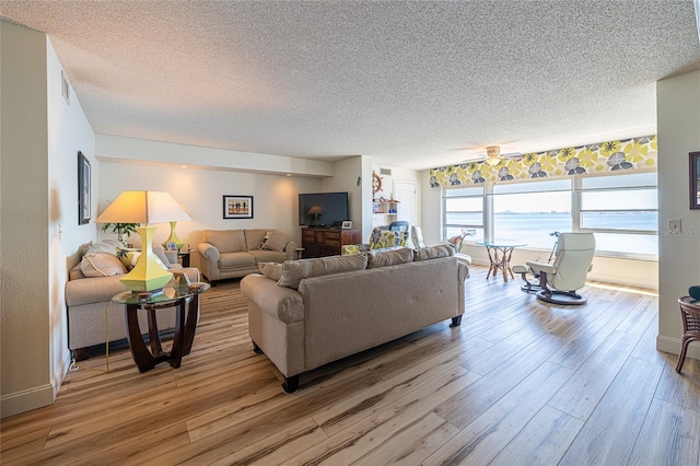 living room with hardwood / wood-style floors, a textured ceiling, and ceiling fan