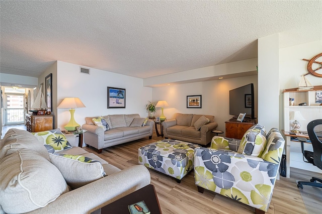 living room featuring a textured ceiling and light hardwood / wood-style flooring