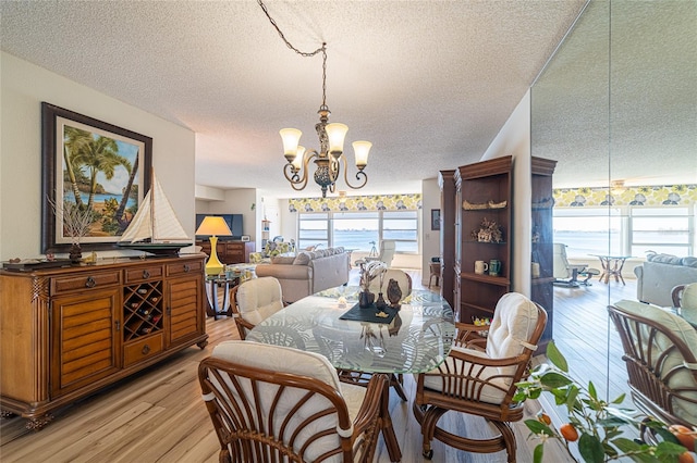 dining space featuring a wealth of natural light, a chandelier, a textured ceiling, and light hardwood / wood-style floors