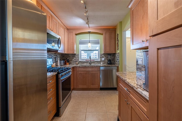 kitchen featuring stainless steel appliances, backsplash, sink, light tile patterned flooring, and light stone counters