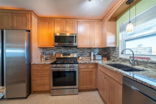 kitchen featuring sink, light stone countertops, stainless steel appliances, and tasteful backsplash