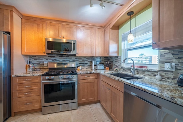 kitchen featuring light stone countertops, appliances with stainless steel finishes, sink, and decorative backsplash