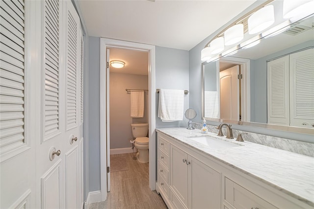 bathroom featuring vanity, toilet, and wood-type flooring