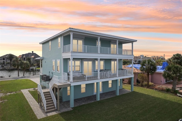339 55th Ave, St Pete Beach, FL 33706 - rear view of house with a balcony, a yard, central AC, and a water view