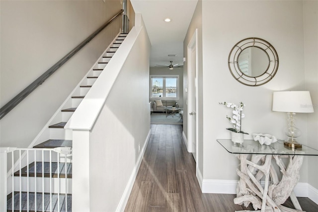 stairs featuring hardwood / wood-style flooring and ceiling fan