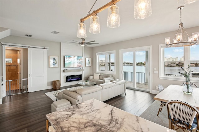 339 55th Ave, St Pete Beach, FL 33706 - living area with a barn door, dark wood finished floors, a ceiling fan, and a chandelier