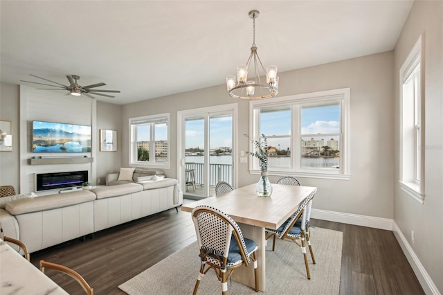 339 55th Ave, St Pete Beach, FL 33706 - dining area featuring dark wood-style floors, baseboards, a chandelier, a glass covered fireplace, and a ceiling fan