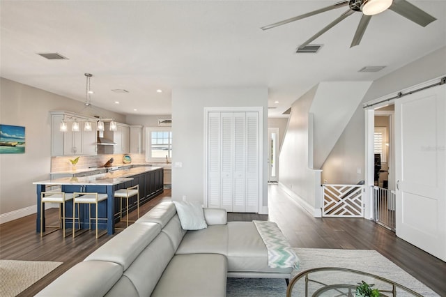 339 55th Ave, St Pete Beach, FL 33706 - living room with dark wood finished floors, a ceiling fan, baseboards, a barn door, and recessed lighting