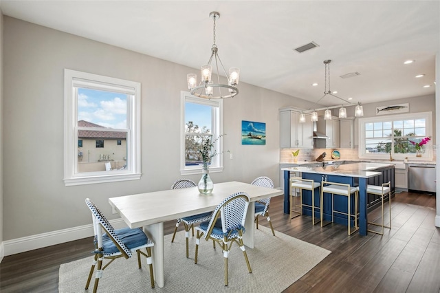 dining area featuring dark wood-type flooring and an inviting chandelier