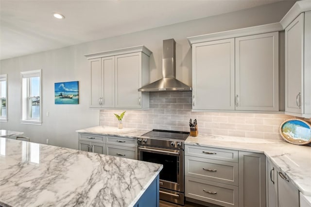 339 55th Ave, St Pete Beach, FL 33706 - kitchen featuring wall chimney exhaust hood, stainless steel range with electric stovetop, light stone counters, tasteful backsplash, and recessed lighting