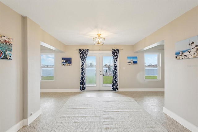 entrance foyer with french doors and a notable chandelier