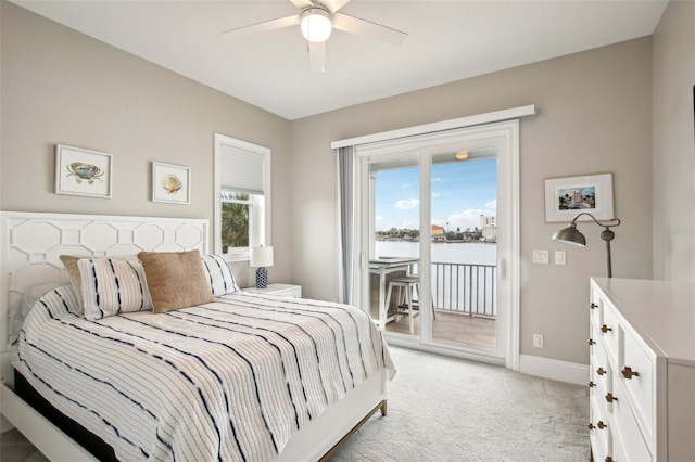 carpeted bedroom with a water view, access to exterior, and ceiling fan