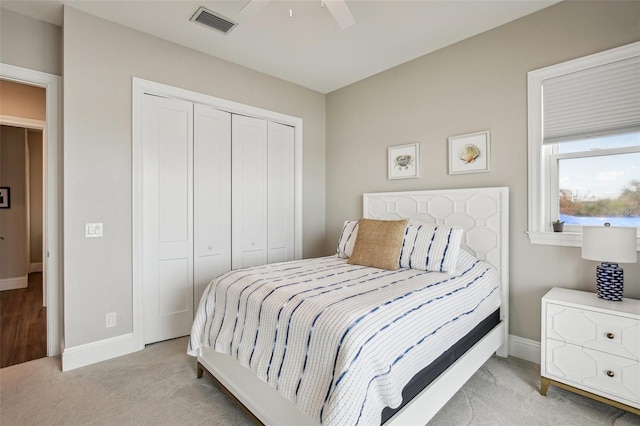 bedroom with light carpet, a closet, and ceiling fan