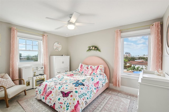 bedroom with light carpet, multiple windows, and ceiling fan