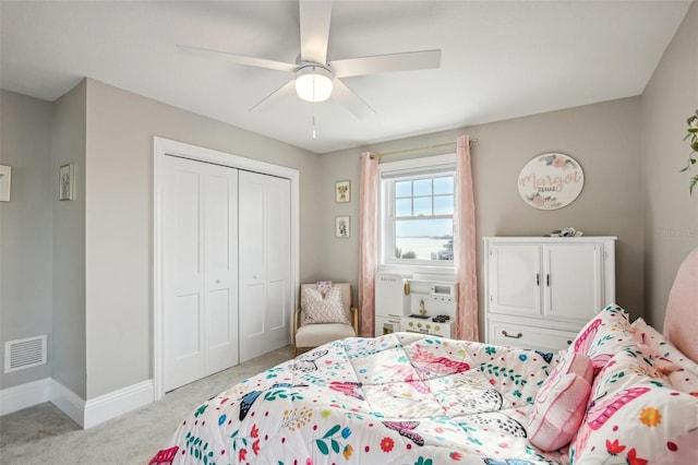 bedroom featuring light colored carpet, a closet, and ceiling fan