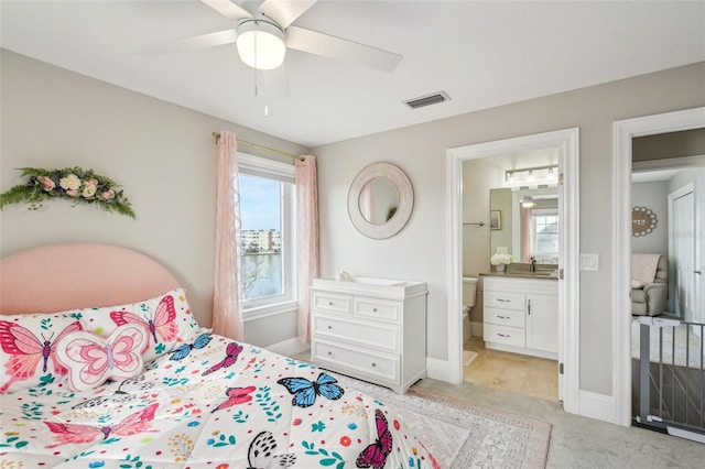 carpeted bedroom with sink, connected bathroom, and ceiling fan