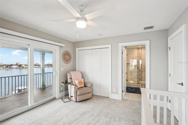 339 55th Ave, St Pete Beach, FL 33706 - bedroom with light carpet, access to exterior, a closet, a water view, and baseboards