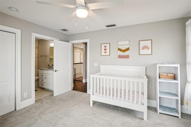 339 55th Ave, St Pete Beach, FL 33706 - bedroom with light colored carpet, baseboards, a ceiling fan, and connected bathroom