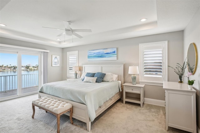 339 55th Ave, St Pete Beach, FL 33706 - bedroom featuring access to exterior, a tray ceiling, light carpet, recessed lighting, and multiple windows