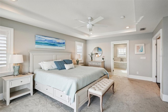 339 55th Ave, St Pete Beach, FL 33706 - bedroom featuring light carpet, a tray ceiling, recessed lighting, baseboards, and ensuite bath