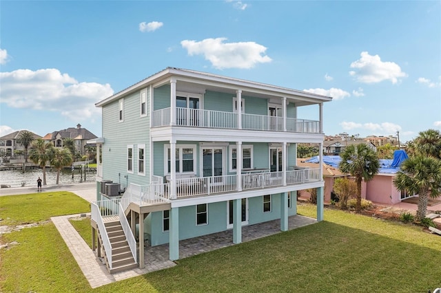 339 55th Ave, St Pete Beach, FL 33706 - back of property featuring a balcony, central air condition unit, a yard, and stairway