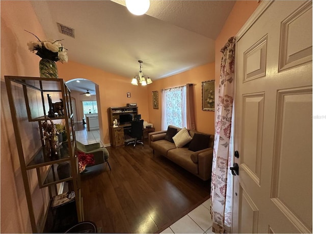 living room featuring a wealth of natural light, hardwood / wood-style flooring, and ceiling fan with notable chandelier