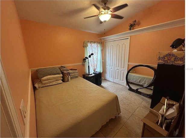 tiled bedroom with a closet, ceiling fan, and lofted ceiling