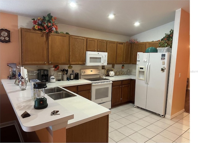 kitchen with white appliances, light tile patterned flooring, and kitchen peninsula