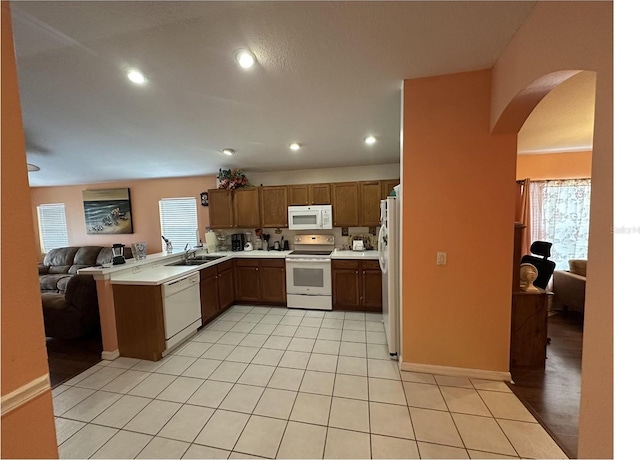 kitchen with a wealth of natural light, sink, light hardwood / wood-style floors, and white appliances