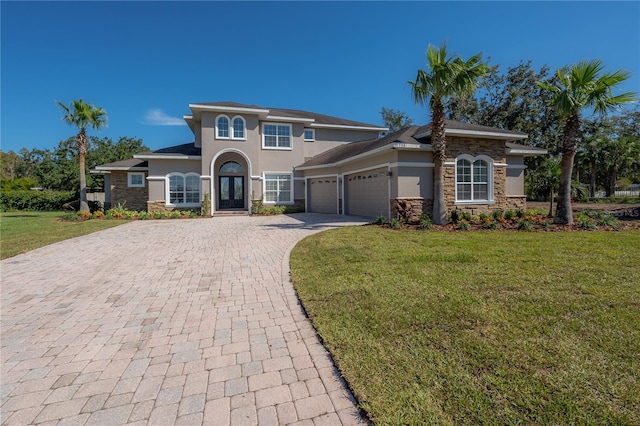 mediterranean / spanish house featuring a front yard and a garage