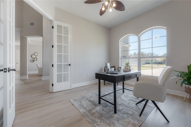 office featuring light hardwood / wood-style floors, french doors, a healthy amount of sunlight, and ceiling fan