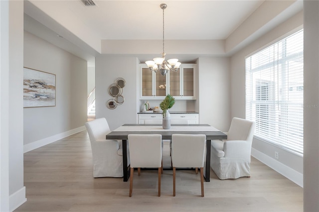 dining space with a chandelier and light wood-type flooring