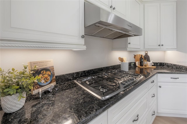 kitchen featuring white cabinetry, dark stone counters, and gas stovetop