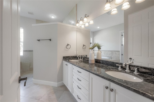 bathroom featuring vanity, a tile shower, a notable chandelier, and tile patterned flooring