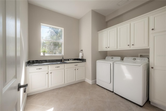 laundry area with sink, light tile patterned flooring, cabinets, and washer and clothes dryer