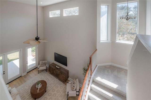 living room featuring ceiling fan, light wood-type flooring, and plenty of natural light