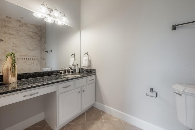 bathroom featuring toilet, vanity, tile patterned floors, and tiled shower