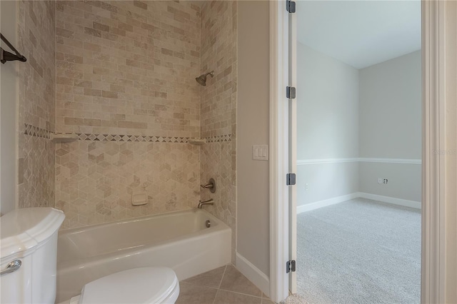 bathroom with tiled shower / bath, tile patterned floors, and toilet