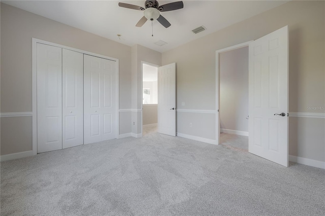 unfurnished bedroom with light carpet, a closet, and ceiling fan