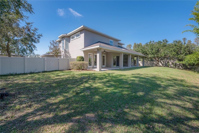 back of house with a yard and a patio area