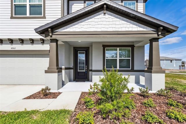 doorway to property featuring a garage and a porch