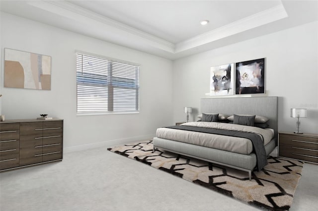 carpeted bedroom with crown molding and a raised ceiling