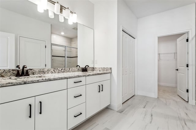 bathroom with vanity and a shower with shower door