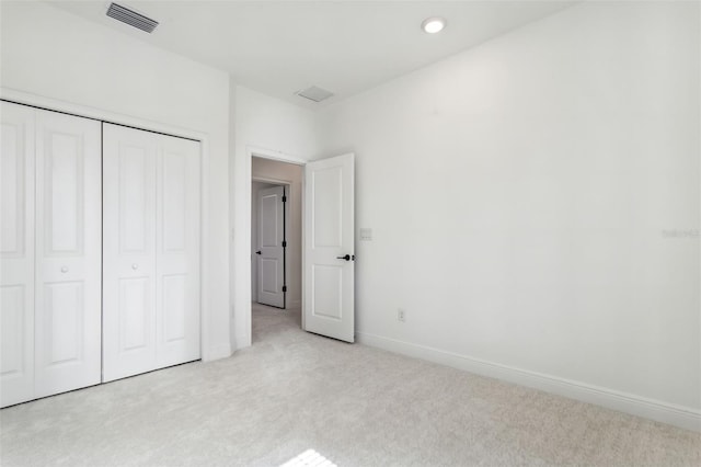 unfurnished bedroom featuring a closet and light carpet